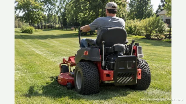 A zero-turn mower sitting still on an open lawn with freshly cut stripes behind it, the operator seated with both lap-bar levers pushed fully forward, seen from the rear three-quarter.